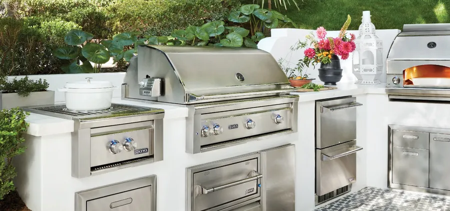 Lynx outdoor kitchen with a built-in grill, side burner, warming drawer, refrigerator and pizza oven